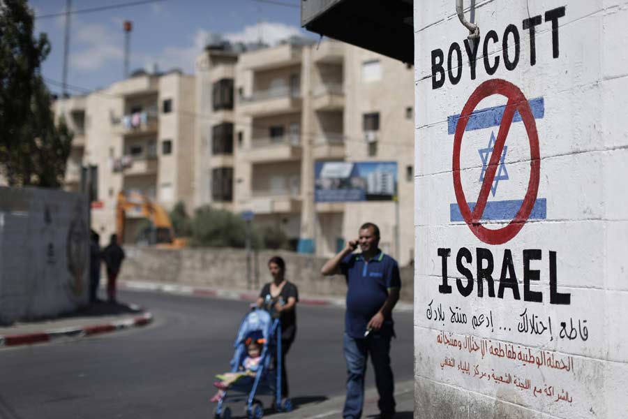 A sign painted on a wall in Bethlehem calling for a boycott of Israeli goods. (Photo: Thomas Coex/AFP/Getty Images)