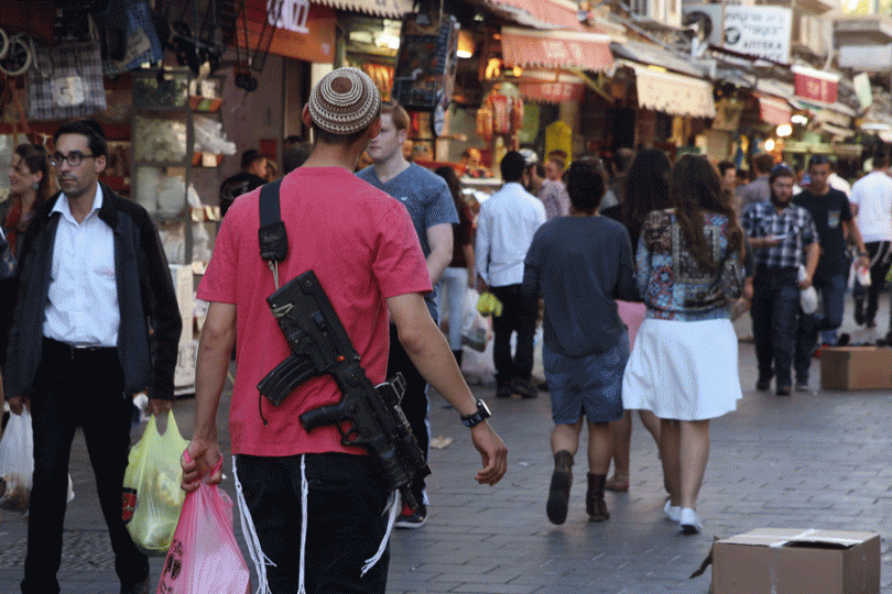 Muž s puškou na cestě z hypermarketu.